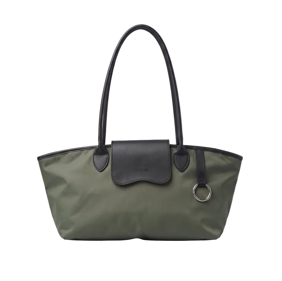 An olive green nylon tote bag with black leather handles, trim, and a front flap pocket, featuring a silver-tone metal O-ring, photographed on a light gray background.