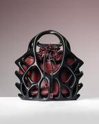 Black and red handbag with floral design on a gradient background
