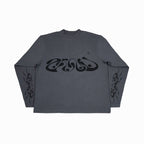 A flat lay of the same dark grey long-sleeved shirt with the swirl design on the chest and tribal pattern on the sleeves.
