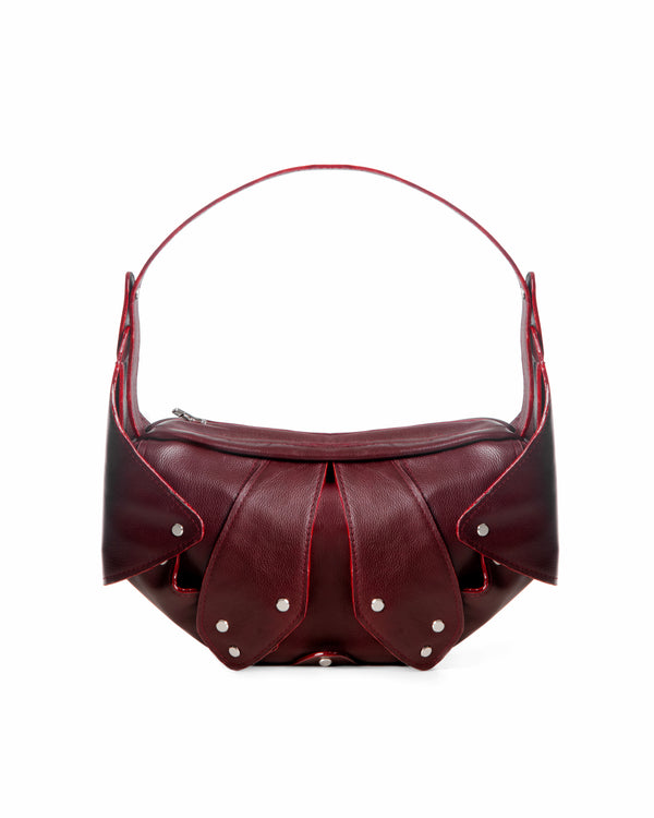 Maroon handbag with pearl embellishments on a white background